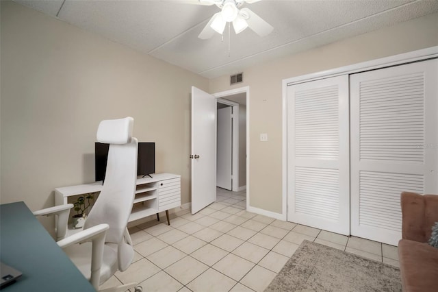 tiled home office featuring ceiling fan