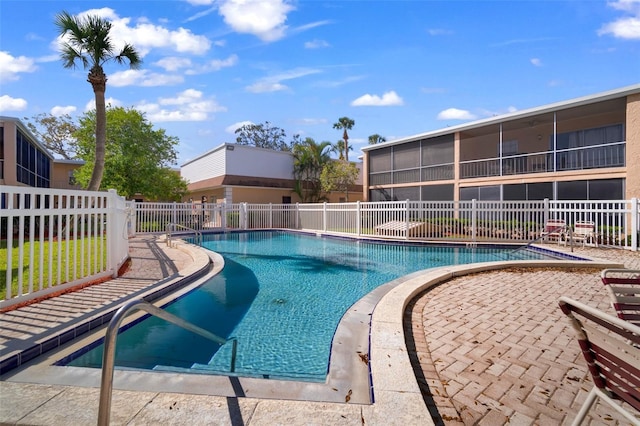 view of swimming pool featuring a sunroom