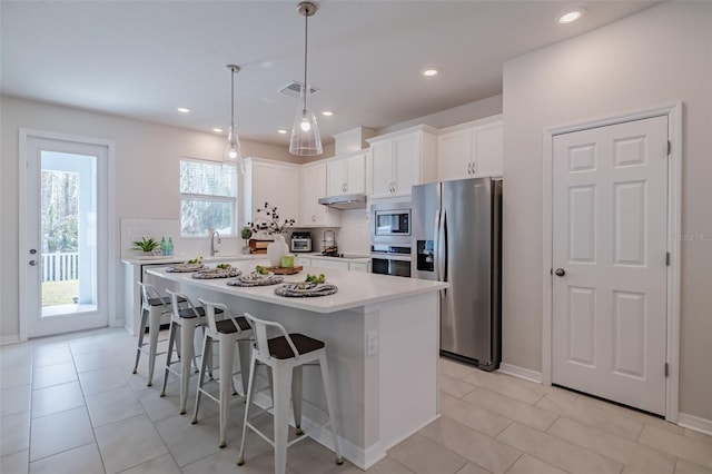 kitchen featuring stainless steel appliances, a kitchen island, and white cabinets