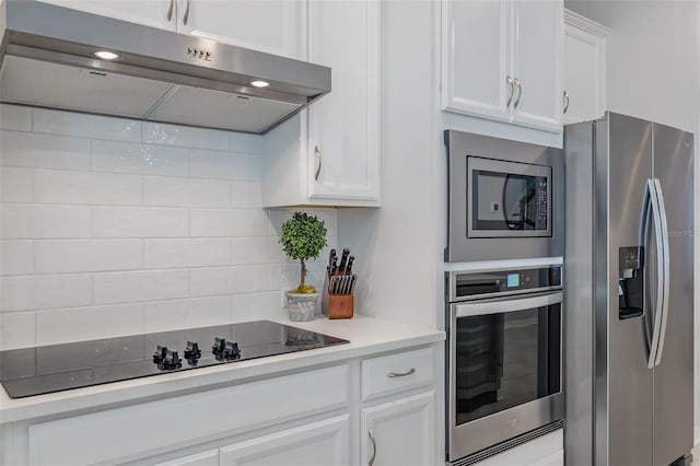 kitchen with white cabinetry, appliances with stainless steel finishes, and tasteful backsplash