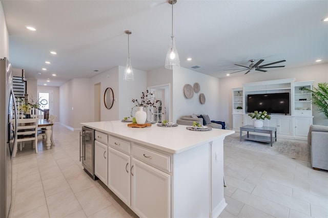 kitchen featuring wine cooler, white cabinetry, decorative light fixtures, light tile patterned floors, and a kitchen island