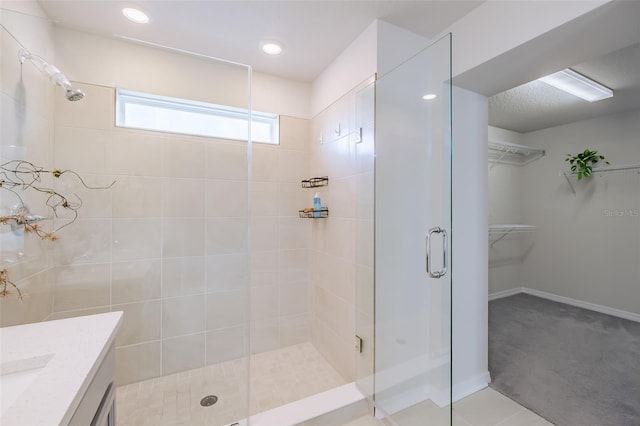 bathroom featuring vanity, tile patterned floors, and walk in shower