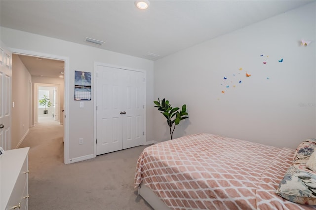 bedroom with light colored carpet and a closet