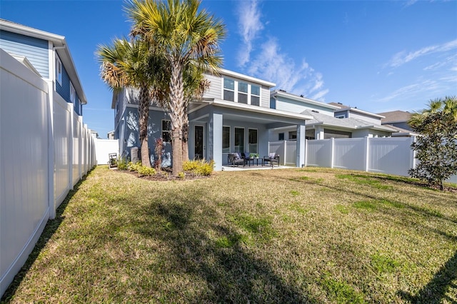 rear view of property with a patio and a yard