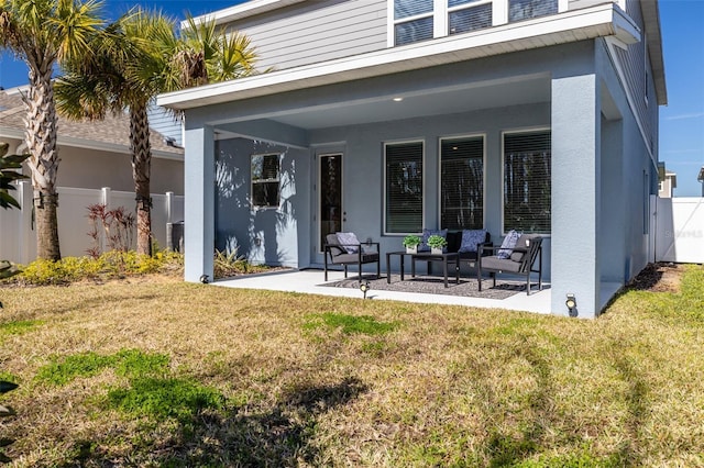 rear view of house with a lawn and a patio