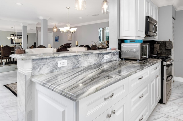 kitchen featuring appliances with stainless steel finishes, white cabinets, a chandelier, hanging light fixtures, and light stone countertops