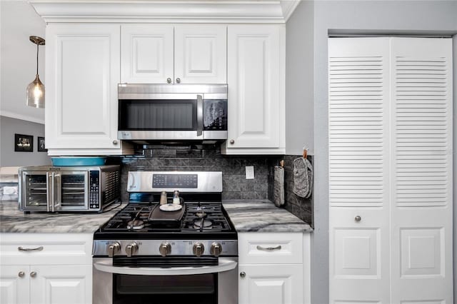 kitchen with tasteful backsplash, white cabinetry, appliances with stainless steel finishes, and ornamental molding