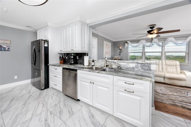 kitchen with appliances with stainless steel finishes, sink, white cabinets, ornamental molding, and kitchen peninsula