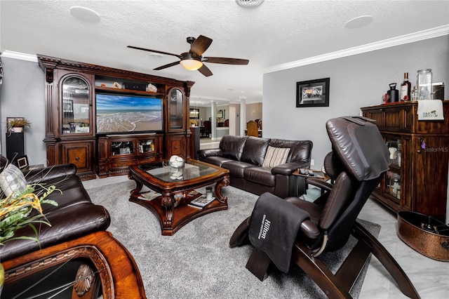 living room featuring ornate columns, crown molding, ceiling fan, and a textured ceiling