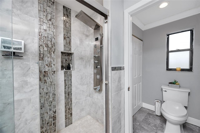 bathroom featuring ornamental molding, toilet, and tiled shower