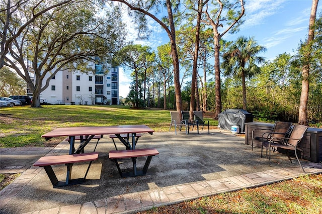 view of home's community featuring a patio area and a lawn