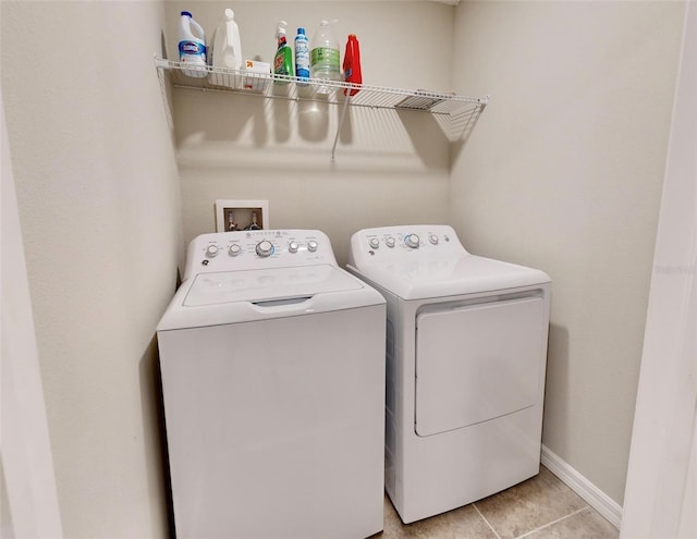 clothes washing area with light tile patterned floors and washer and dryer