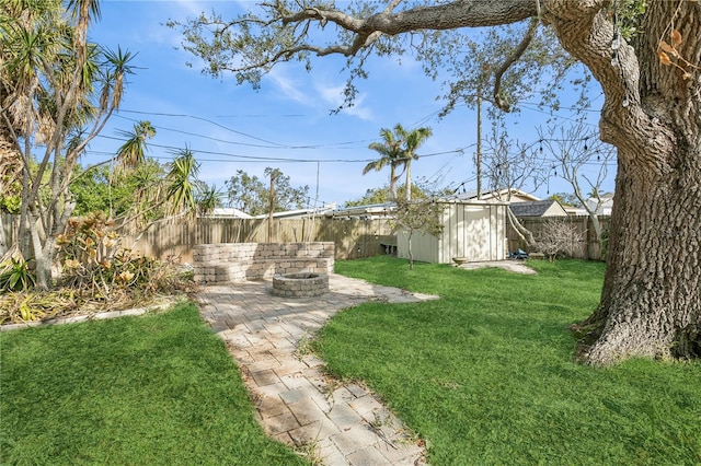 view of yard featuring a storage unit, a patio area, and a fire pit