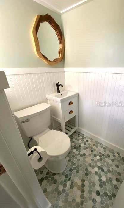 bathroom featuring tile patterned flooring, vanity, and toilet