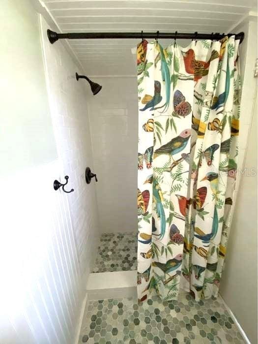 bathroom featuring curtained shower and tile patterned floors