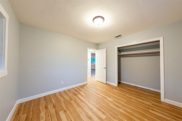 unfurnished bedroom with light hardwood / wood-style floors and a closet