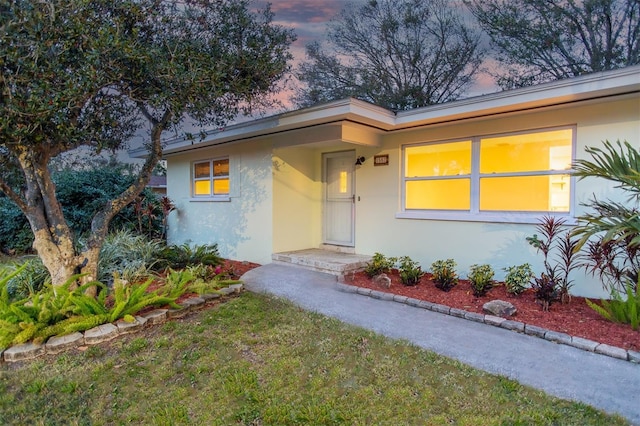 exterior entry at dusk with a lawn