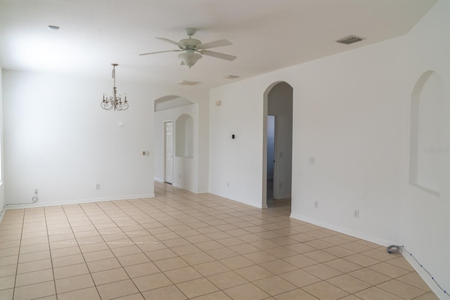 tiled spare room with ceiling fan with notable chandelier