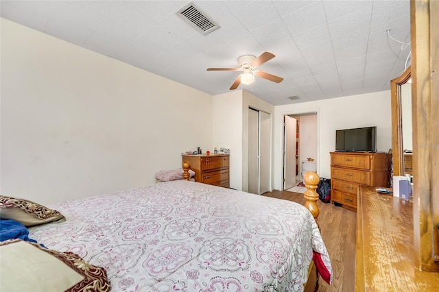 bedroom with light hardwood / wood-style floors, a closet, and ceiling fan