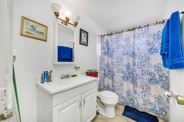 bathroom featuring tile patterned flooring, vanity, toilet, and walk in shower