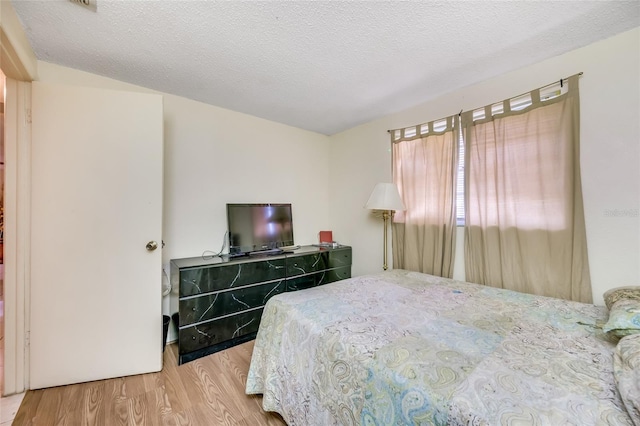 bedroom with hardwood / wood-style floors and a textured ceiling