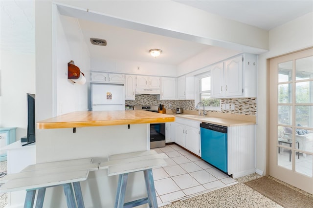 kitchen with decorative backsplash, dishwasher, white cabinets, and white refrigerator