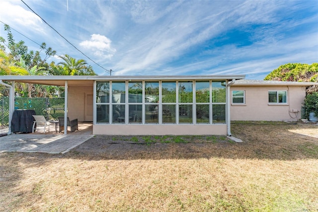 rear view of property featuring a patio and a lawn