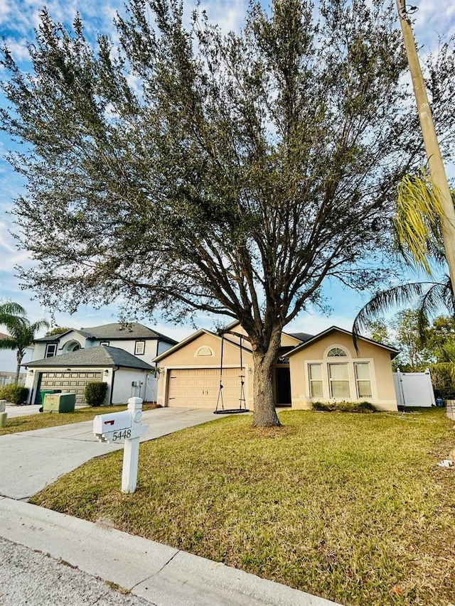 single story home featuring a garage and a front yard