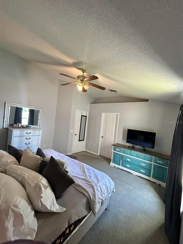 bedroom featuring dark carpet, ceiling fan, vaulted ceiling, and a textured ceiling