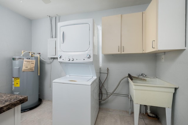 washroom with stacked washer / drying machine, light tile patterned floors, cabinets, and water heater