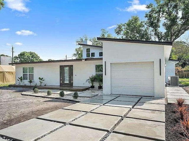 view of front facade featuring cooling unit and a garage