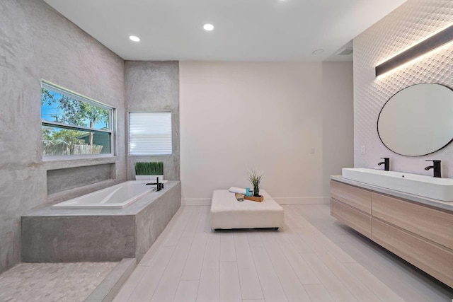 bathroom featuring vanity and tiled bath