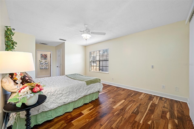 bedroom with ceiling fan, dark hardwood / wood-style floors, and a textured ceiling