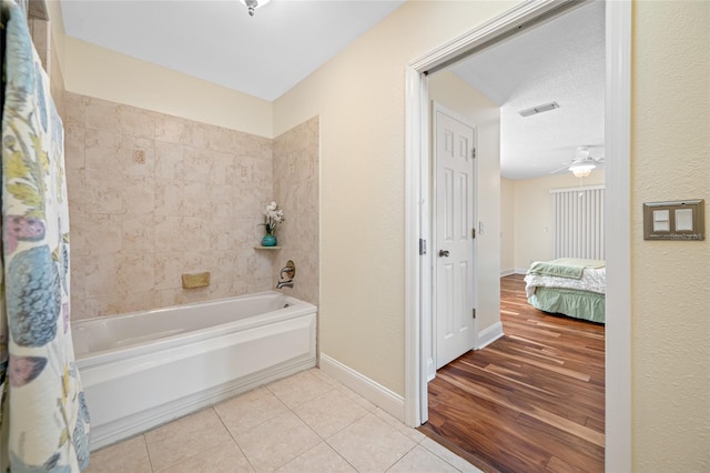 bathroom with tile patterned flooring, ceiling fan, and shower / bath combo with shower curtain