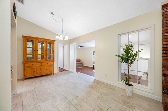 unfurnished dining area featuring lofted ceiling and a chandelier