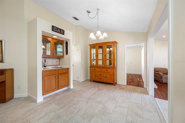 dining space with vaulted ceiling, sink, a notable chandelier, and light hardwood / wood-style floors