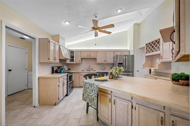 kitchen featuring lofted ceiling, sink, decorative backsplash, stainless steel appliances, and light brown cabinets