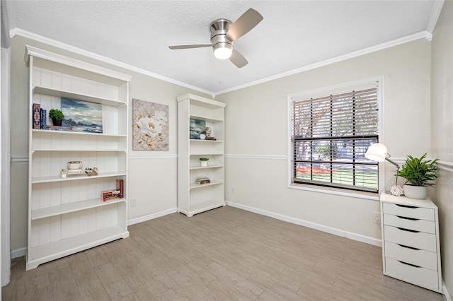 interior space featuring ornamental molding, a textured ceiling, and light wood-type flooring