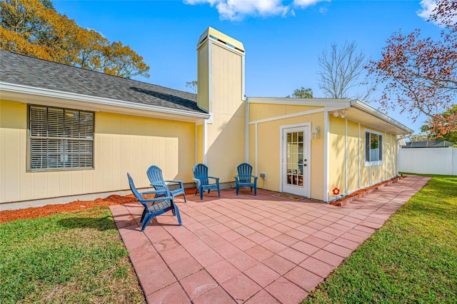 rear view of house featuring a patio and a lawn