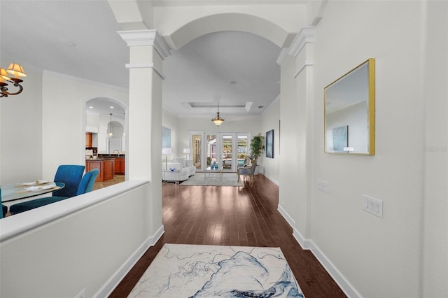 corridor with french doors, ornamental molding, dark hardwood / wood-style floors, and ornate columns