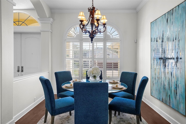 dining room with ornamental molding, wood-type flooring, a chandelier, and decorative columns