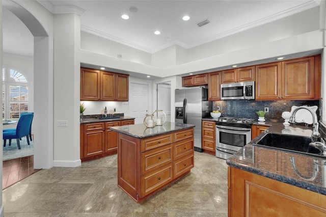 kitchen featuring stainless steel appliances, a center island, sink, and dark stone counters