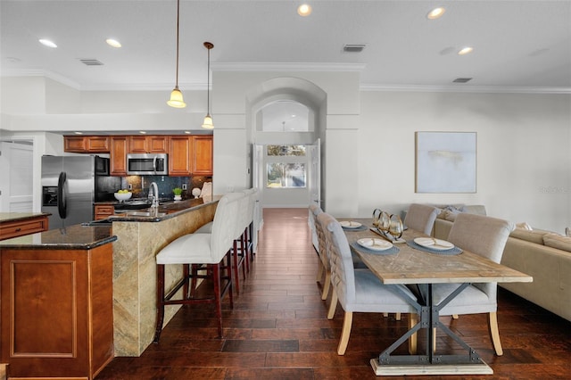 dining area with crown molding and dark hardwood / wood-style flooring