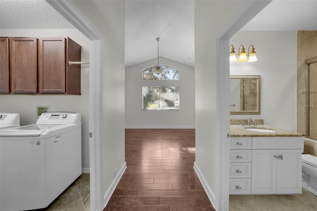 laundry area with hardwood / wood-style floors, washer / clothes dryer, sink, cabinets, and a textured ceiling