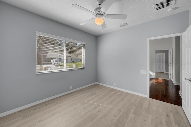 spare room with ceiling fan, a textured ceiling, and light wood-type flooring