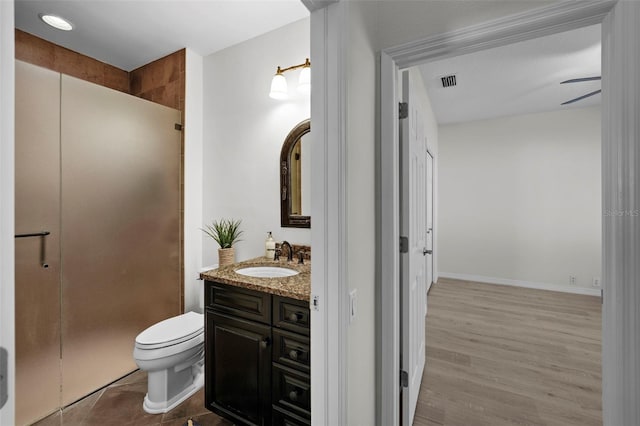 bathroom featuring hardwood / wood-style flooring, vanity, toilet, and a shower