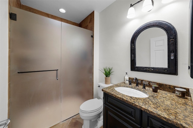 bathroom featuring vanity, toilet, and an enclosed shower