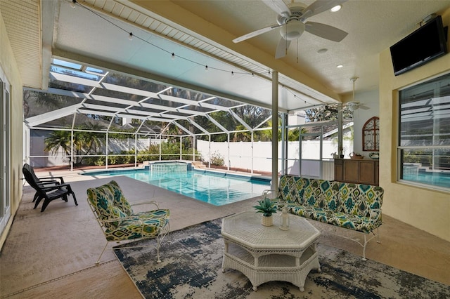 view of pool with ceiling fan, a lanai, and a patio area