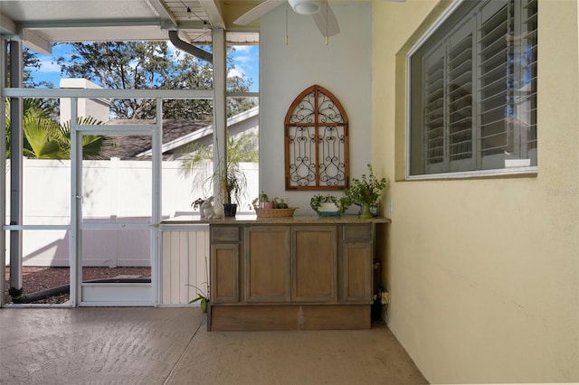 unfurnished sunroom featuring ceiling fan and a wealth of natural light