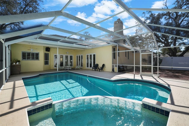 view of pool featuring a lanai, a patio area, ceiling fan, and french doors